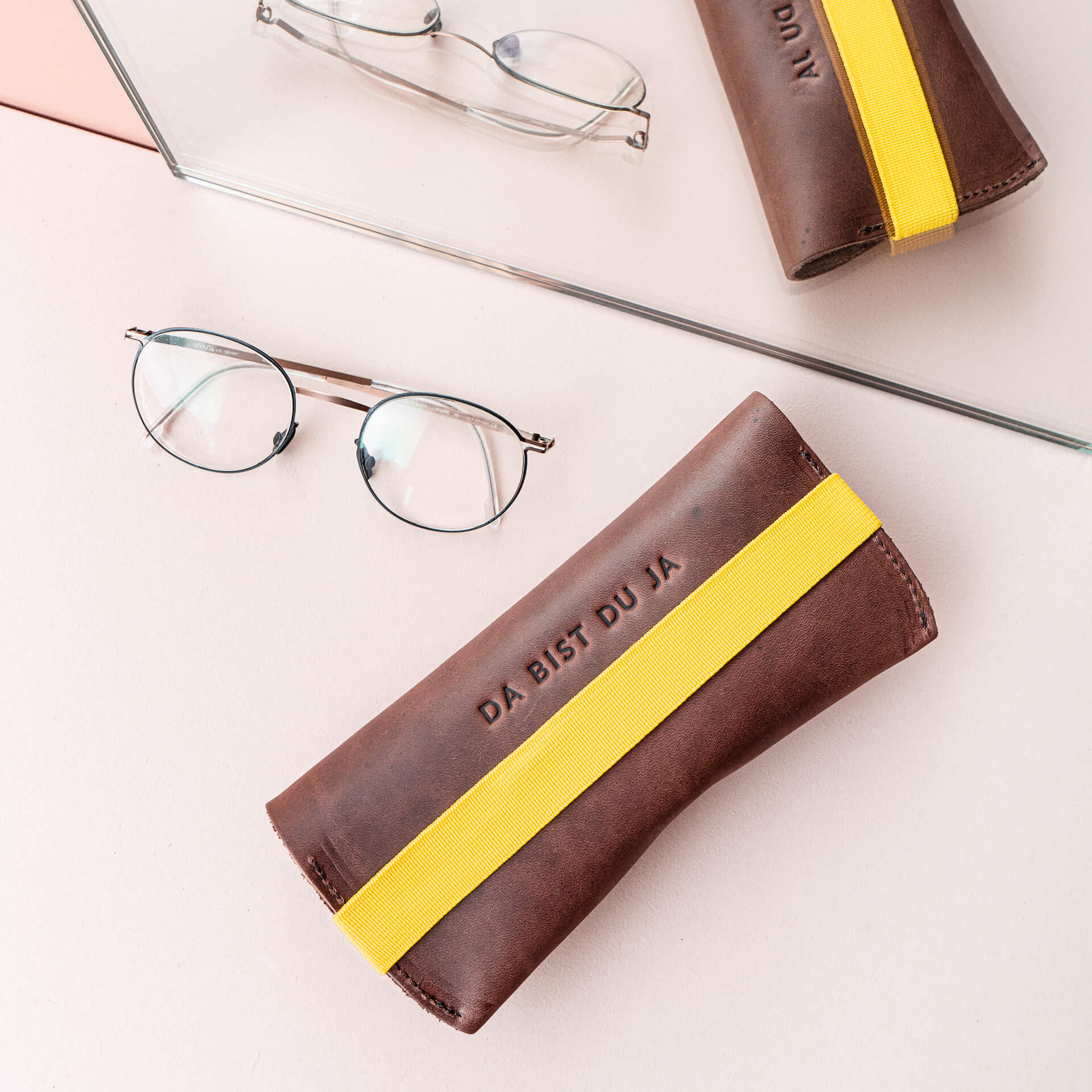Spectacle case LUK in dark brown with yellow closure band back with individual embossing