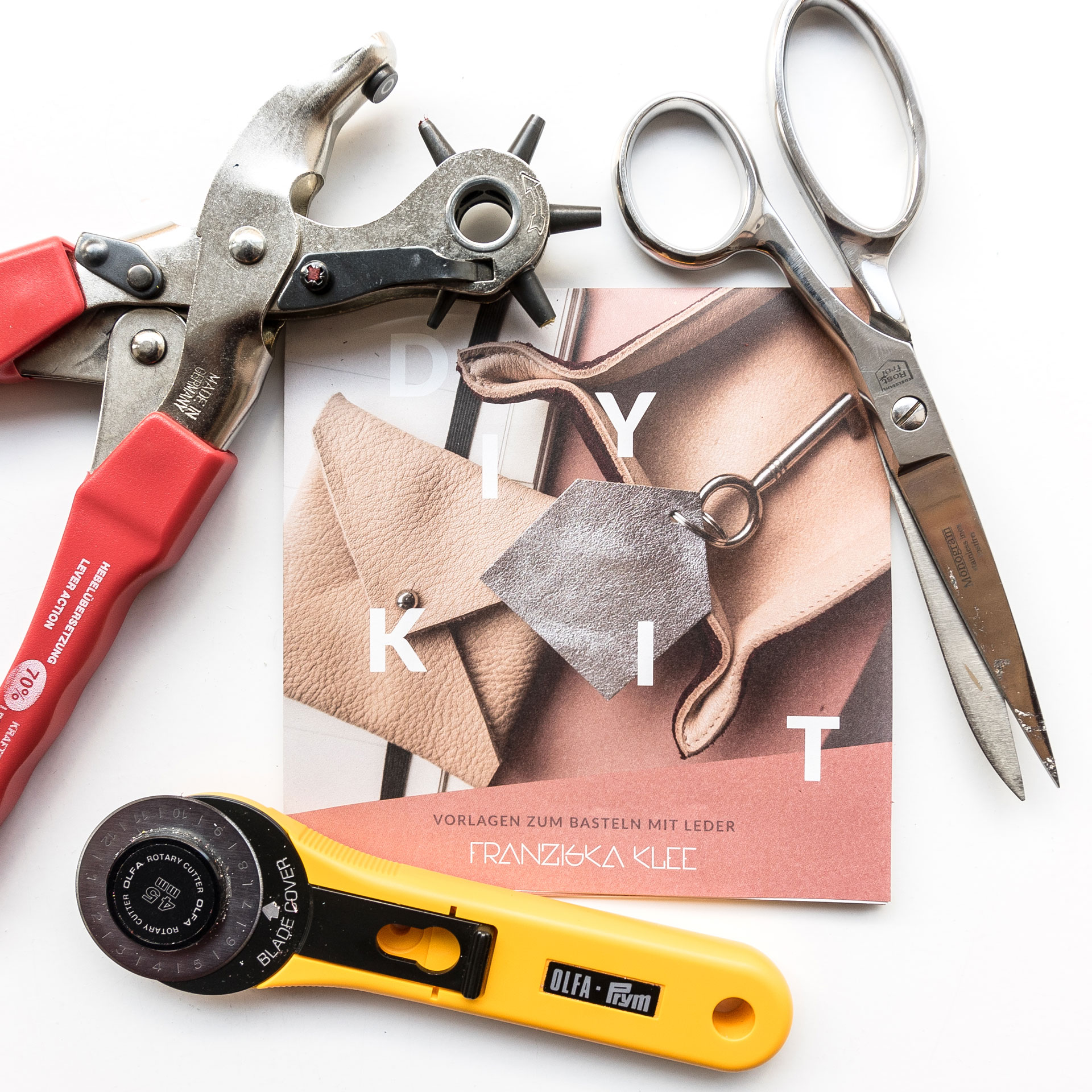 DIY craft sheet and useful accessories like scissors, hole punch and rotary cutter