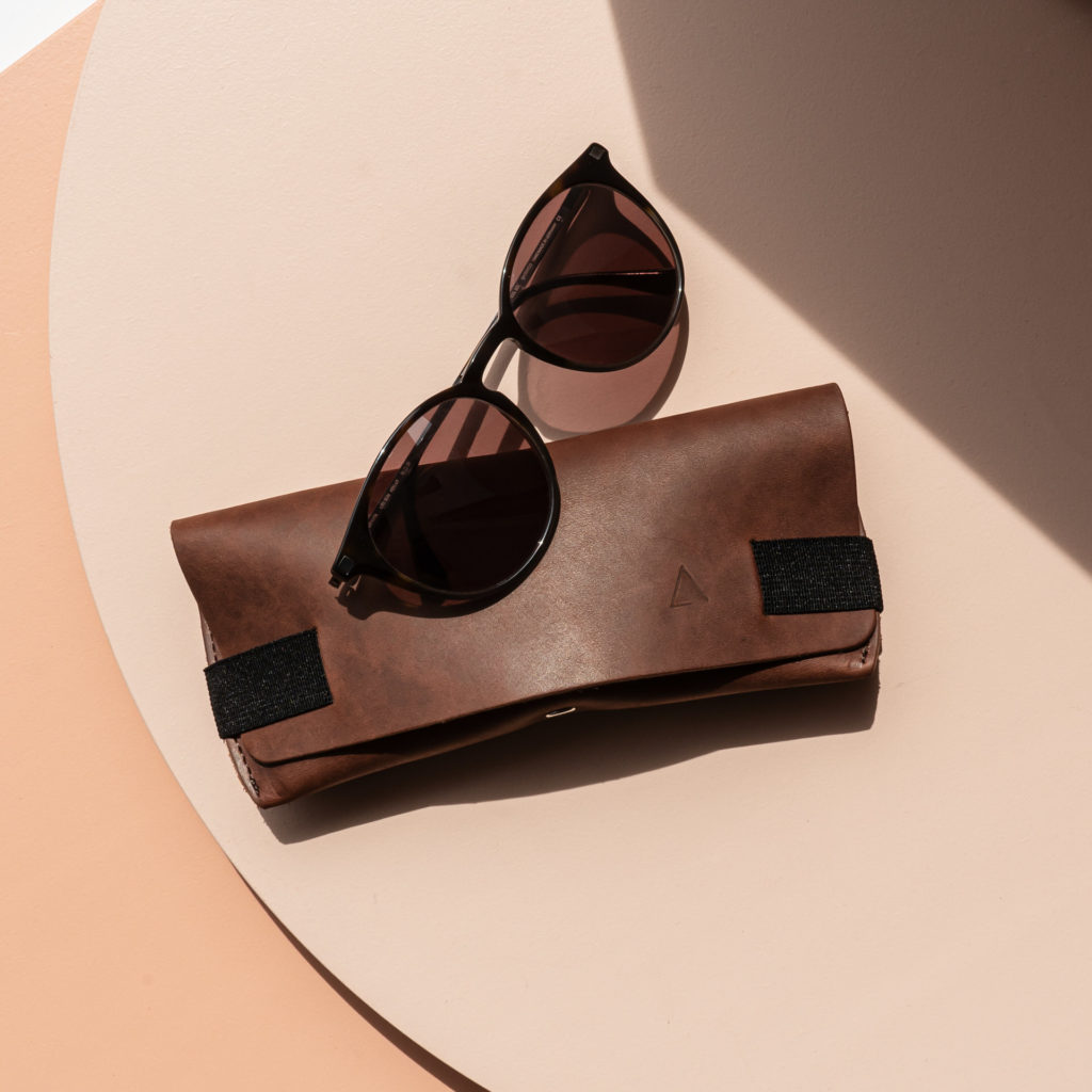 Spectacle case LUK in dark brown with black closure strap from the front with sunglasses