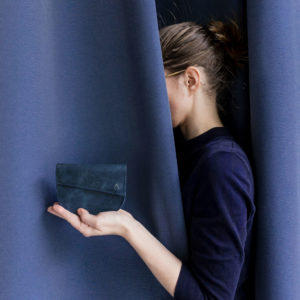 Model holds wallet UNA dark blue sustainable natural leather