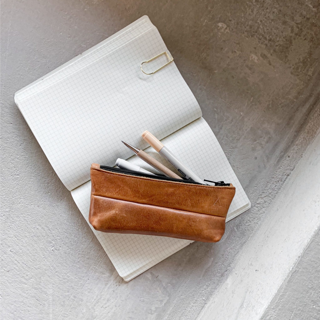 Pencil case PEN made of sustainable natural leather in cognac oiled on notebook with pens