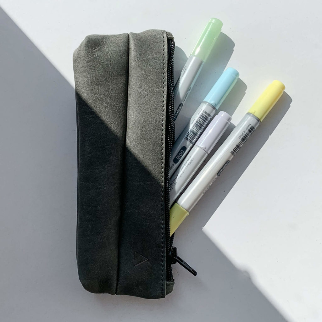 Top view of pencil case PEN made of sustainable natural leather in stone gray with pens
