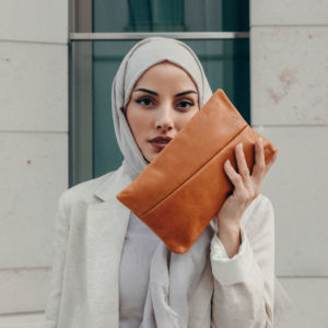 Model holding 3-in-1 bag Isa in color cognac oiled made of natural leather.