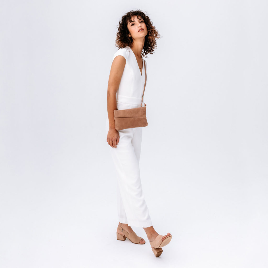 Model wears 3-in-1 bag Isa in light brown color made of natural leather.