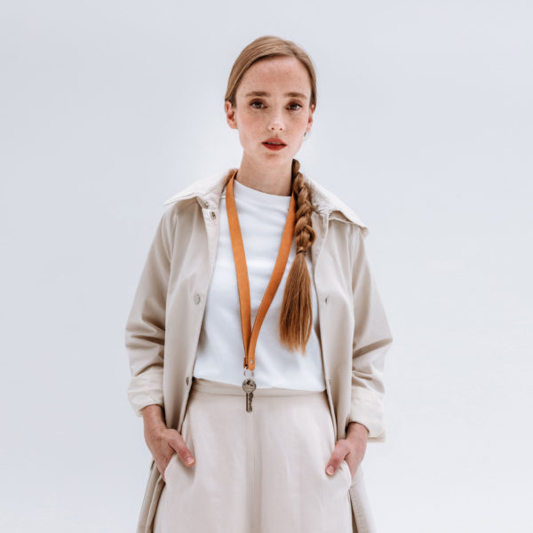 Model wears lanyard LOC Large in the color cognac around the neck.
