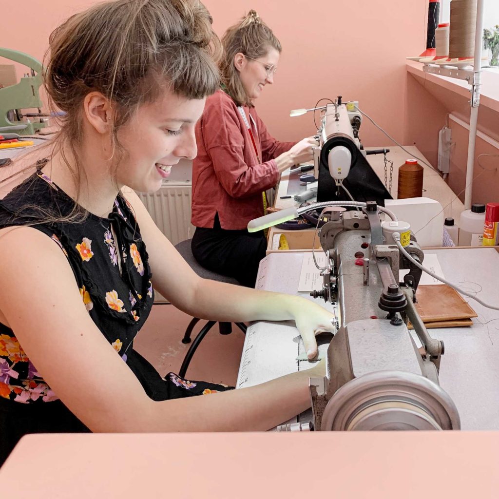 Franziska Klee and Franziska Wentz sew on sewing machines in the studio showroom