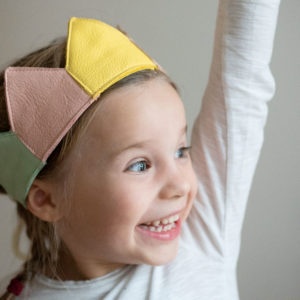 Girl wearing configured birthday crown in yellow, pink and mint