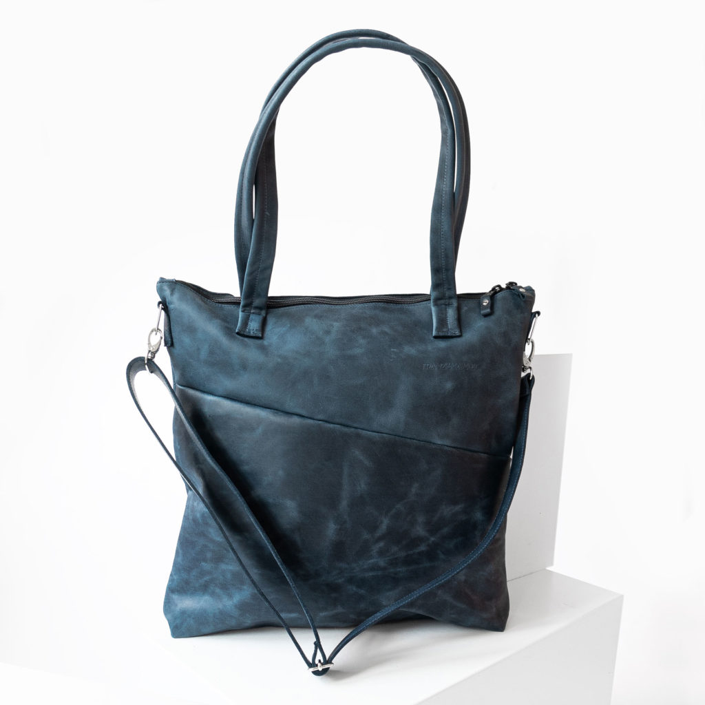 Front of the diaper bag MIA MIDI made of sustainable natural leather in dark blue with long handles, detachable shoulder strap and discreet logo embossing