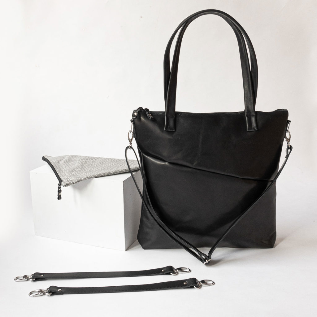 Diaper bag MIA MIDI made of natural leather in black oiled with attached shoulder strap and accessories consisting of utensil bag and suspension for the stroller.