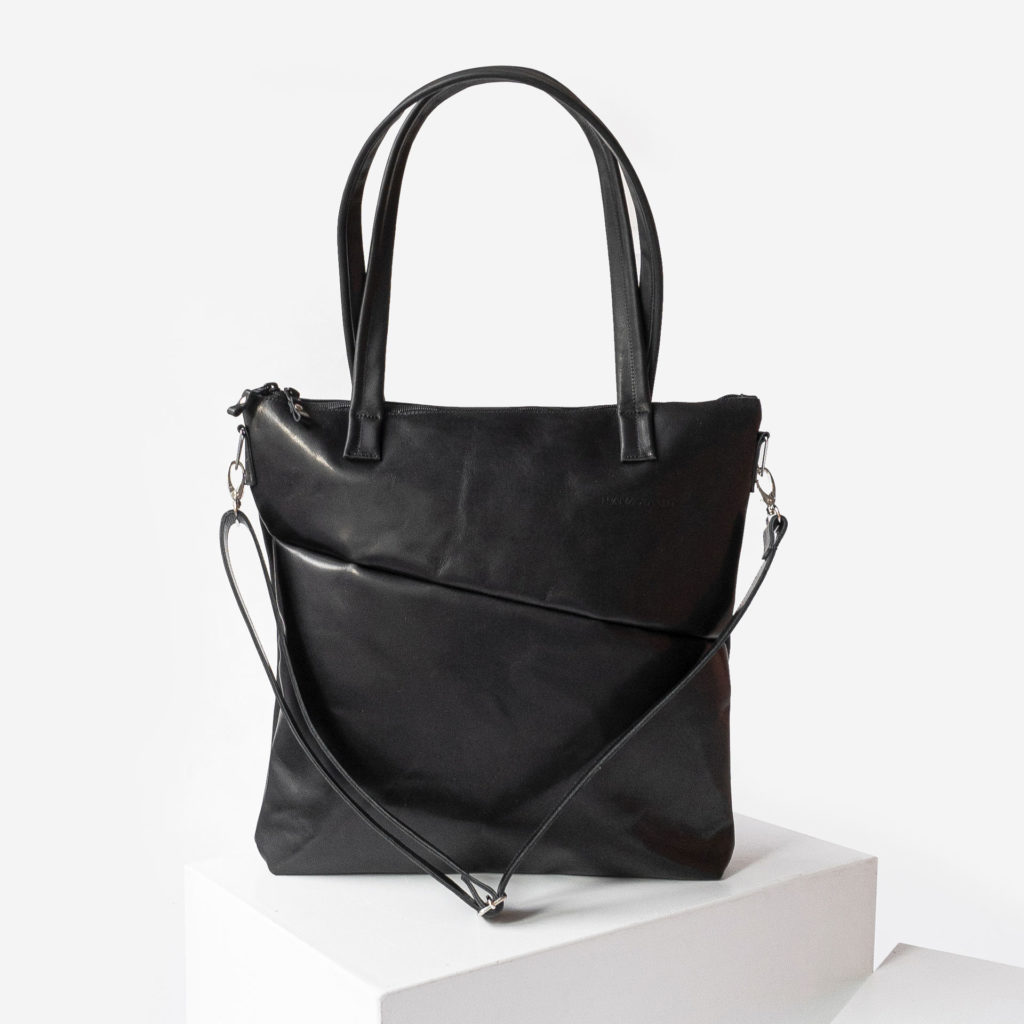 Front of the diaper bag MIA MIDI made of sustainable natural leather in black oiled with long handles, detachable shoulder strap and discreet logo embossing