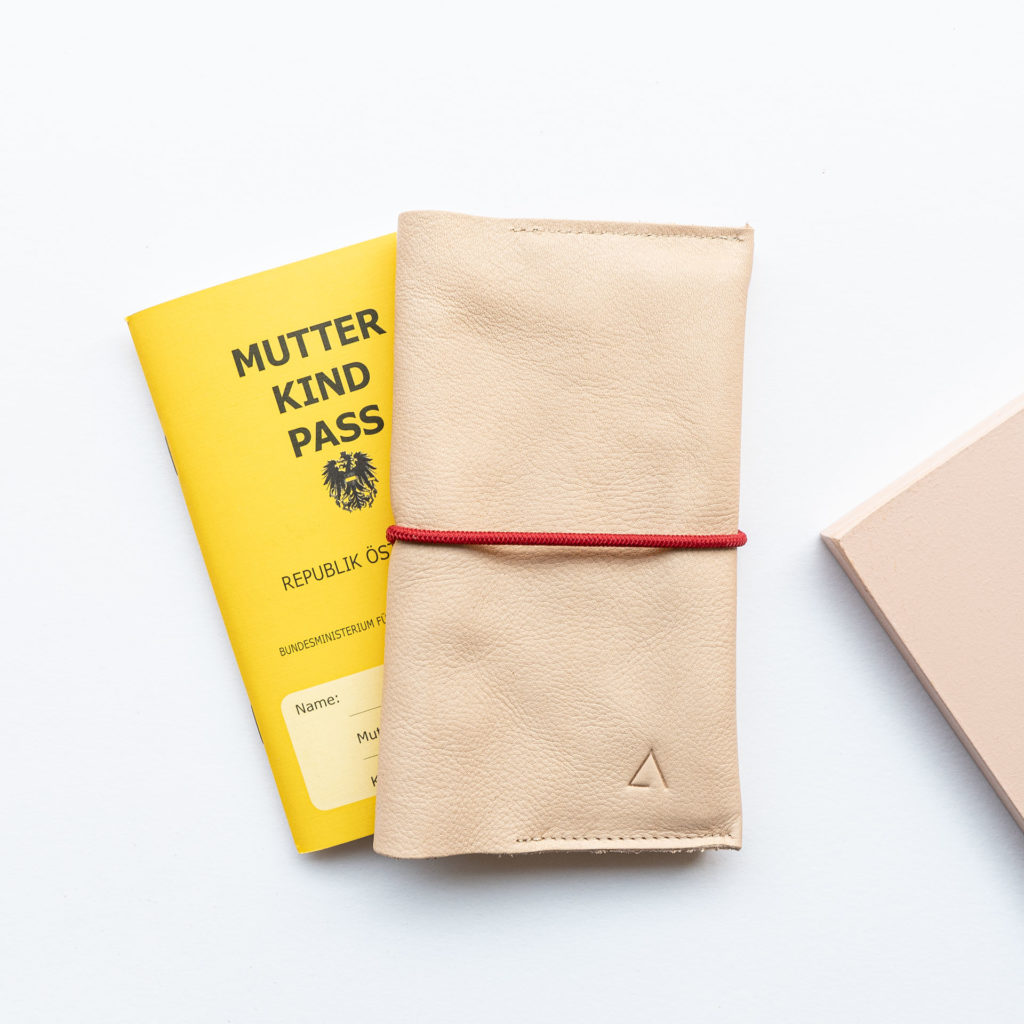Mother and child passport cover EVE Austria made of natural leather in beige with discreet logo embossing and red closure band