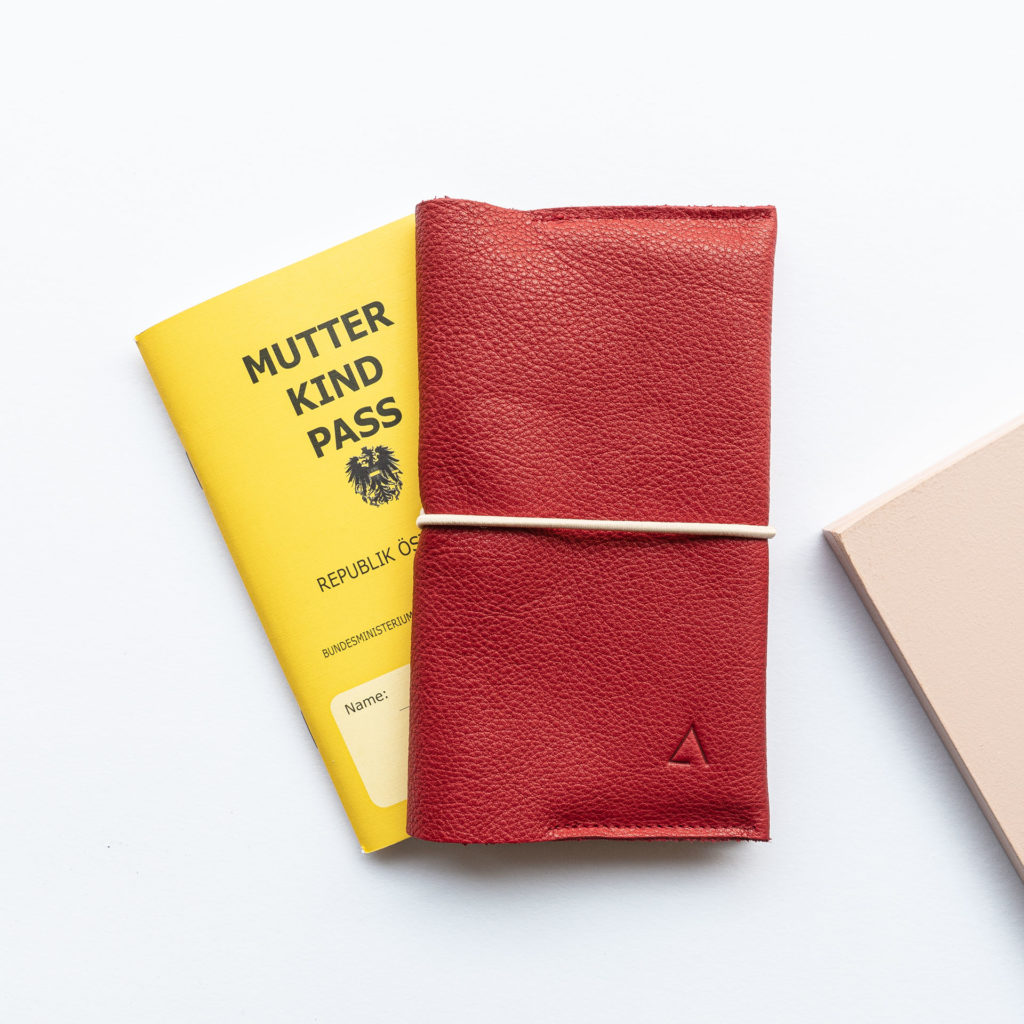 Mother and child passport cover EVE Austria made of natural leather in red with discreet logo embossing and cream-colored closure band
